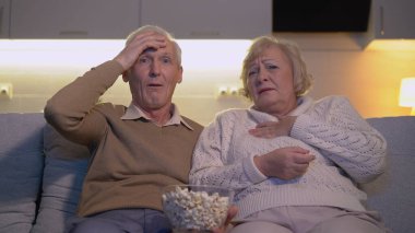 Şok olmuş bir aile korku filmi seyrediyor ya da kanepede oturup şok olmuş hissediyorlar.