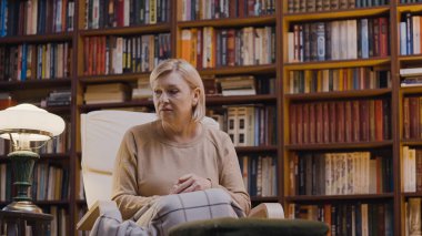 Evde otururken kendini yalnız hisseden üzgün yaşlı kadın, akıl sağlığı sorunları.