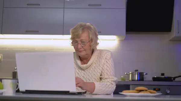 A mature lady looking for new cookie recipes and entering a query into the browser search bar