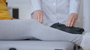 Kemik durumunu kontrol etmek için bir hastanın bacağından alçı almaya hazırlanan bir travmatoloğun yakın çekimi.