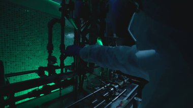 Bilim adamı, tehlikeli testler sırasında nükleer reaktördeki basıncı düzenleyen vanaları ayarlıyor.