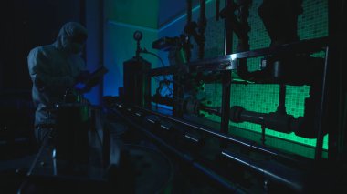 Koruyucu teçhizat bilim adamı, biyolojik tehlike oluşturan deneysel bir fabrikada testler yapıyor.