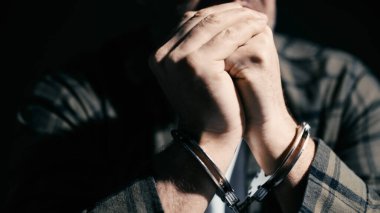 Polis, soruşturma ve sorgulama tarafından kelepçelenmiş korkmuş bir adam.