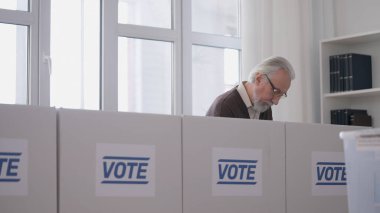 Demokratik bir ülkede seçim günü, oy kullanma kabininde yaşlı bir adam