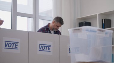 Oy kullanma merkezinde oy veren orta yaşlı bir adam, başkanlık seçim günü, demokrasi