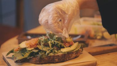 Şef, restoranda taze salataya avokado dilimleri, yemek tasarımı ve sunum yapıyor.