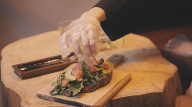 Avokado tostu üzerine somon dilimi hazırlamak, fotoğraf çekimi için yemek hazırlamak.