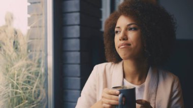 Kahvesini yudumlayan zarif bir kadın güne huzur ve rahatlıkla başlıyor.