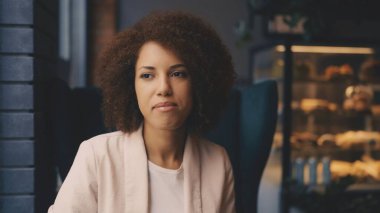 Güzel Afrikalı Amerikalı kadın kafe 'de dinleniyor, sıcak ve düşünceli.