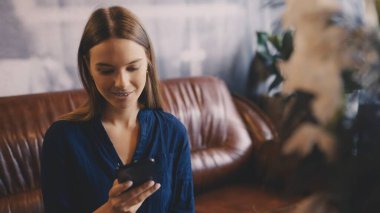 Kafeteryada dinlenirken telefonda sohbet eden güzel bir kadın.