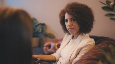 Kafede kahve içerken rahatça sohbet eden iki bayan arkadaş.