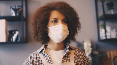 Yüz maskeli barista kahve hazırlıyor ve emirler alıyor, covid-19 güvenlik protokolü