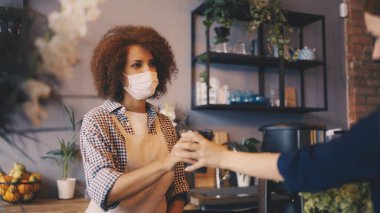 Siyahi kadın, kahve dükkanında müşterilerle çalışıyor, salgın güvenliği için.