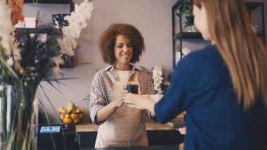 Neşeli siyah barista bayan müşteriye kahve ve kek siparişi veriyor.