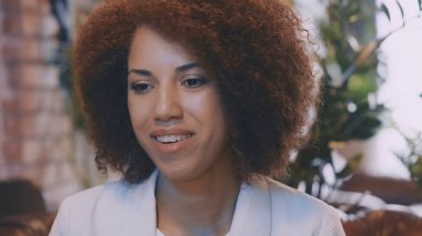 Gülümseyen serbest yazar video görüşmesi yapıyor, online toplantı sırasında kameraya bakıyor.