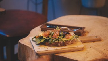 Susam tohumlu avokado tostu, rahat kafe ortamında servis edilir.