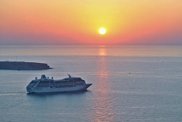Oia, Greece - September 16 2011:  Giant cruiser ship on the sea. Sunset. Vacation on Santorini islands, Greece.