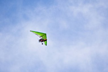 Yeşil motorlu planörlü adam uçuşunun tadını çıkarıyor..