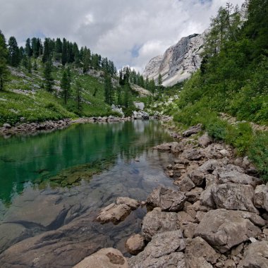 Yedi Göl Vadisi 'ndeki Mocivec Gölü. Etrafı yüksek dağlar ve kayalarla çevrili. Triglav Ulusal Parkı 'ndaki muhteşem manzara Triglav dağ zirvesine birkaç saat uzaklıkta. Slovenya.