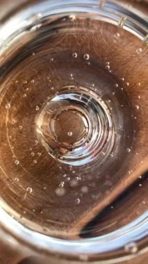 Şeffaf camda köpüklü limonata içinde kaybolan kabarcıklar. Ayrıntıları kapat.