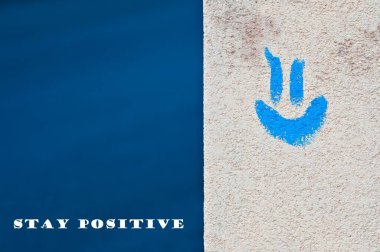 Pozitif duygu ve gülümseme kavramı. Binaya bakan mavi emoji ve mavi arka plan. Metin yerleştirmek için negatif kopyalama alanı. Olumlu düşün..