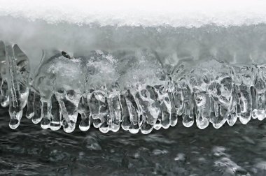 Donmuş nehirde ilginç şekilli buz saçakları. Kış havasının güzelliği. Kışın Çek Cumhuriyeti doğası.