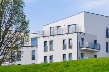 Doğada yeni inşa edilmiş apartmanlar. Modern, ekolojik, genel mimari. Yeni ev yapımı ve yaşam konsepti. Kullanılabilir konut kavramı. Mavi gökyüzü arkaplanı.