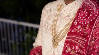 Hintli damat yakın planda, Sherwani giyiyordu. İnci kolyeli, karmaşık tasarımları vardı. 