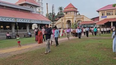 Velha Goa, Eski Goa, Hindistan 28 Nisan 2024 Shri Manguesh Tapınağı kompleksi, tapınağın yemyeşil bahçesinde gezen dindarlar ve ziyaretçilerin bulunduğu canlı bir sahne..