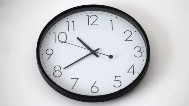 時計は数字で壁の時計に直面し 白い壁の時計が動作し 時計の針の動き ハイライトは時計の手を動かし フィールドの浅い深さ — ストック動画