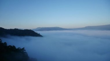 Tayland 'daki dağlarda güzel bir sis denizi var, hava sıcak ve nemli, çok fazla su buharı vadide ön planda bir sis denizi yaratıyor, sis ve dağ tepeli bulutlar.