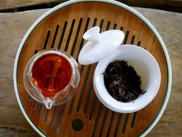 tea from glass teapot on wooden serving tray, Tea making process, Glass teapot at the tea ceremony close up, A cup of balance filled with tea, Healthy fermented puerh herbal teachinese ceremony