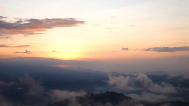 Sis dağların içinden akar, güneş tropikal ormanlara doğru parıldar, sisler sabah dağların tepelerinde sürüklenir, dağın tepesinde yavaşça süzülen sis örtüsü