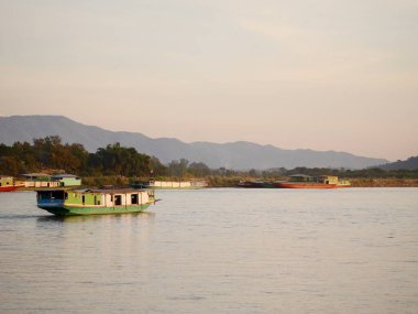  Mekong Nehri boyunca seyreden yavaş bir tekne, Mekong Nehri 'nden hareket eden yerel bir tekne Tayland ve Laos sınırı arasında, nehirde tekne nakliyesi, nakliye gemisi...