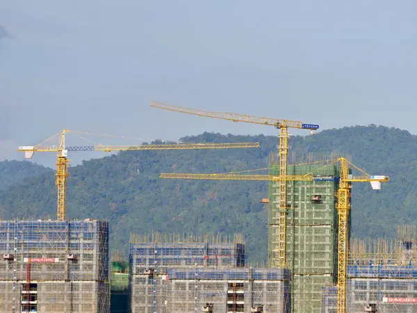 Tower Crane Operating At Development Site, City, crane and construction with apartment buildings, property development, infrastructure, Urban landscape, civil engineering, Casino buildings in Laos