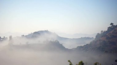 Sis dağların içinden akar, güneş tropikal ormanlara doğru parıldar, sisler sabah dağların tepelerinde sürüklenir, dağın tepesinde yavaşça süzülen sis örtüsü