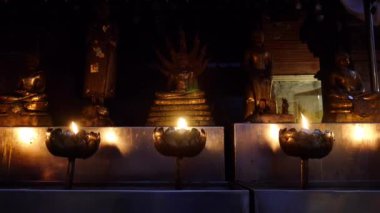 Buddha heykelinin önünde bir mum yak, önünde yanan mumlar.