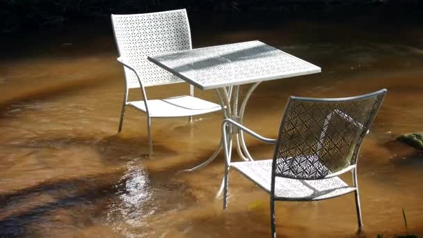 水流过桌子和椅子 美丽的白色椅子和桌子坐在一条天然的溪流中间 有一张茶几放在花园里喝茶 — 图库视频影像