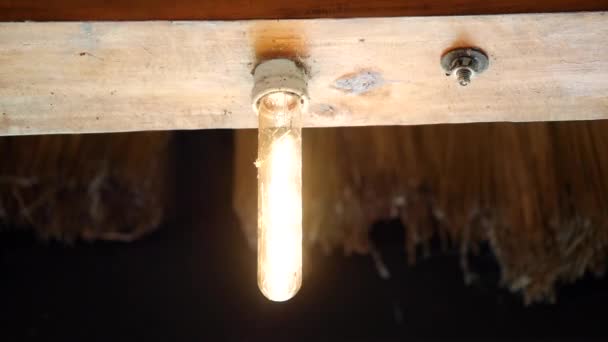 木の天井で明滅するレトロライト電球 閉じる 天井のライト バルブは明滅しましたり 白熱電球は明滅します — ストック動画