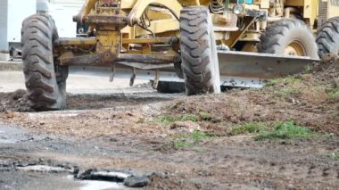 Grader Road Earthworks İnşaat, çakıl döşeme üzerinde çalışan bir not kırsal alanda yol çakıllarını dengeleyen bir yol ölçer, karayolu için pürüzsüz çakıl yüzeyi takibi yapan sarı yol greyderi görüntüsü
