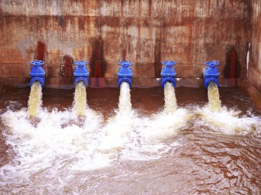 Baraj duvarından su çıkışı. Howell Sığınak vanası çalışıyor, baraj duvarındaki basınçlı su çıkışı, boru hattı suyu, fabrika endüstrisinin borularından akan su.