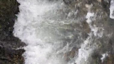 Su dalgaları, köpüklü ve köpüklü su. Su çok dalgalı ve dalgalı görünüyor, içinden büyük miktarda su akan bir su yolu.
