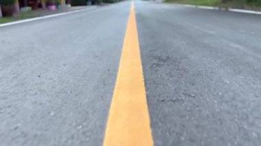 Yolda git, caddenin sarı çizgisini kapat, yaya geçitli asfalt yolu kapat. Koyu gri desenli yüzey, desenli asfalt yüzeyde görünen yol çizgisi