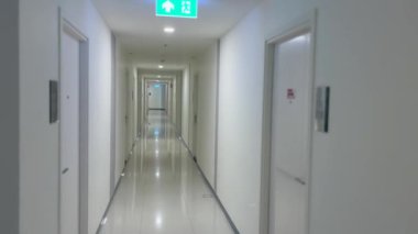 Bir ofis binası veya apartmanda modern koridor, parlak zemin, temiz çizgiler, parlak ışıklandırma, konut binaları, iç tasarım ve gayrimenkul gibi parlak tasarım unsurları barındırıyor.