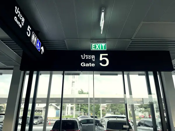 stock image Exit Gate No. 5 at a Thailand airport, featuring a modern and spacious design typical of international travel hubs, travel, transportation, aviation, and international airports, a bustling airport