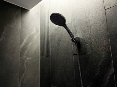 Banyodaki modern duştan akan su, dışarı fışkıran suya odaklan ve yavaşça aksın, damlalar düşsün, banyoda duş başlığı açılıp kapansın.