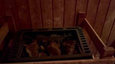 Geleneksel ahşap sauna. Doğal ahşap dokuları ve ahşap kovasıyla fotoğraf, huzurlu bir ortam sunuyor. Rahatlama ve refah için mükemmel bir ortam.