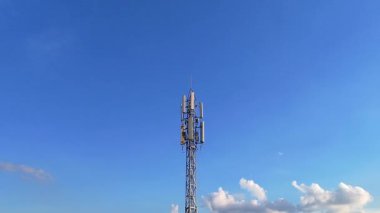 Telekomünikasyon kulesi, günbatımında bir telekomünikasyon kulesinin havadan görünüşü arka planda kırsal manzara, kablosuz iletişimi ve kırsal altyapıyı sembolize ediyor.