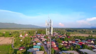 Telekomünikasyon kulesi, günbatımında bir telekomünikasyon kulesinin havadan görünüşü arka planda kırsal manzara, kablosuz iletişimi ve kırsal altyapıyı sembolize ediyor.
