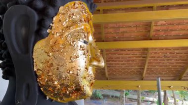 Buda heykeli, altın yaprakla süslenmiş Buda heykeli, Tayland Budizmi 'ne bağlılığı ve ruhani saygıyı simgeliyor, tapınak heykeli.